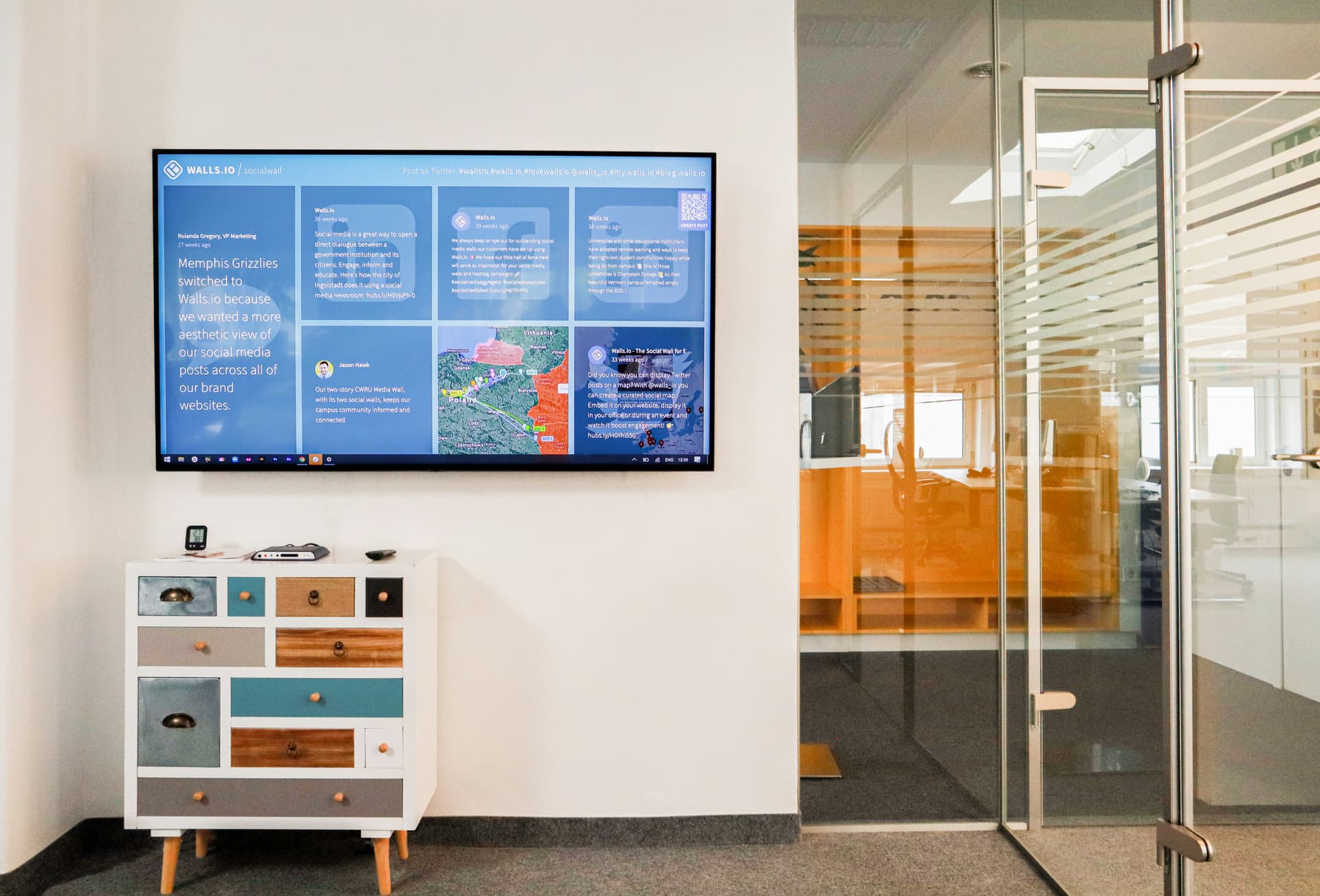 A Power BI dashboard displayed on a large TV screen in an office